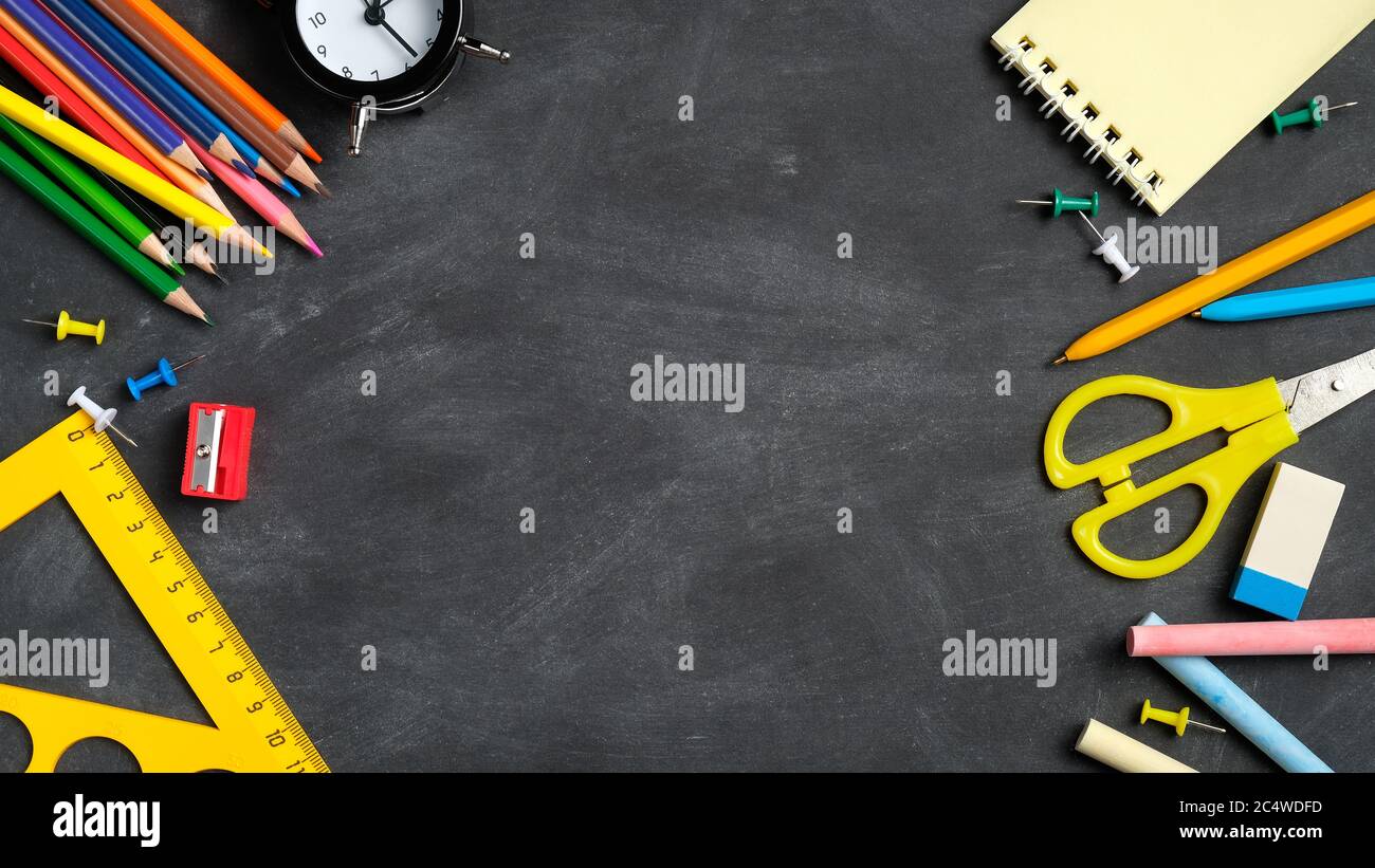 Back to school background with colorful school supplies on black board ...