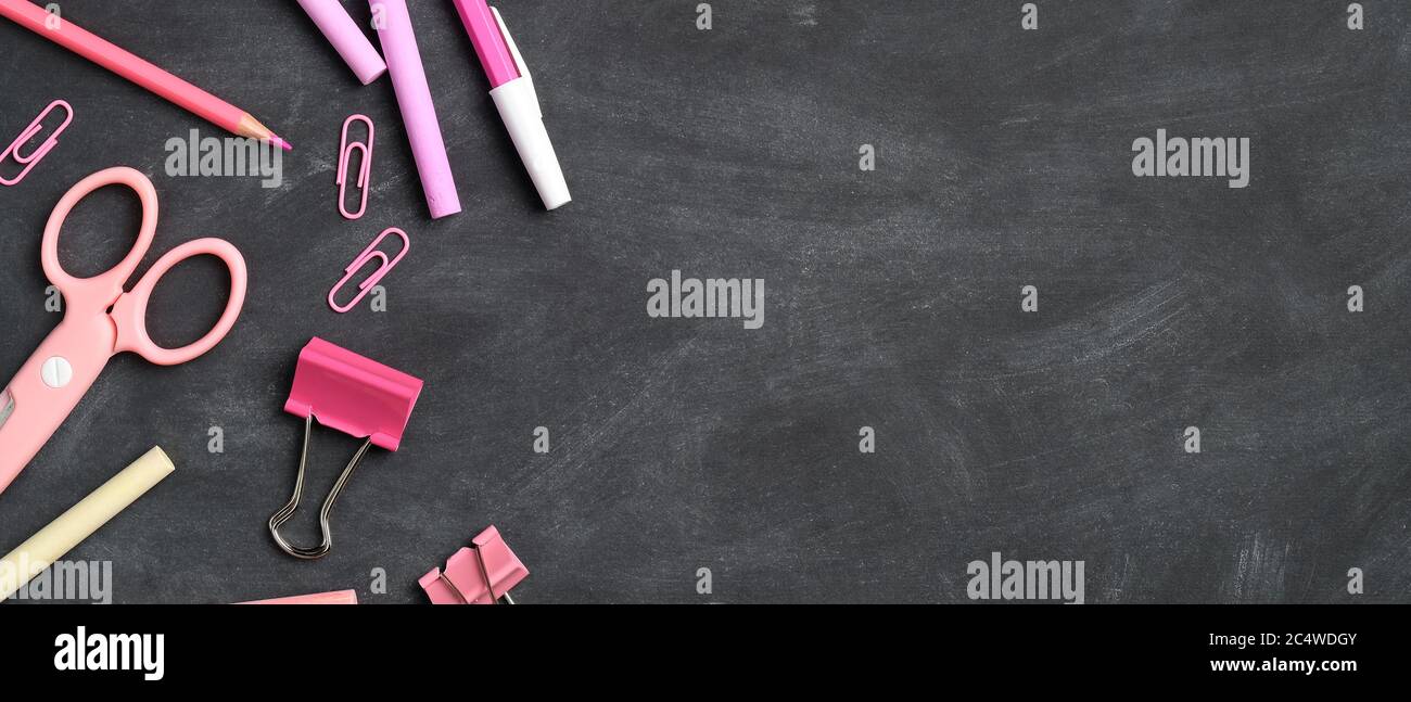 Back to school background with pink office supplies on black. Flat lay ...
