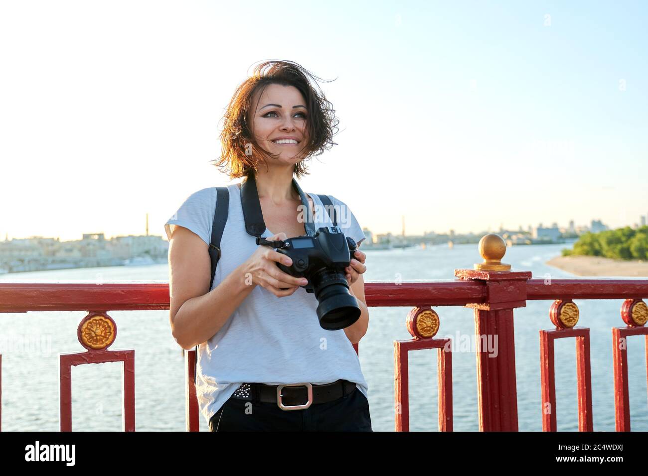 Mature female photographer with professional camera and backpack Stock Photo