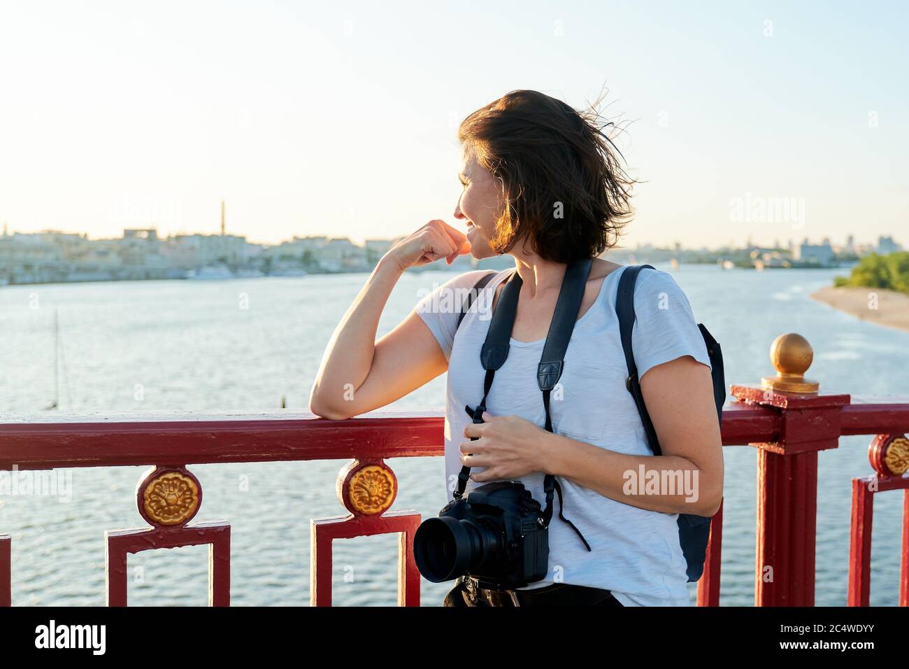 Mature female photographer with professional camera and backpack Stock Photo