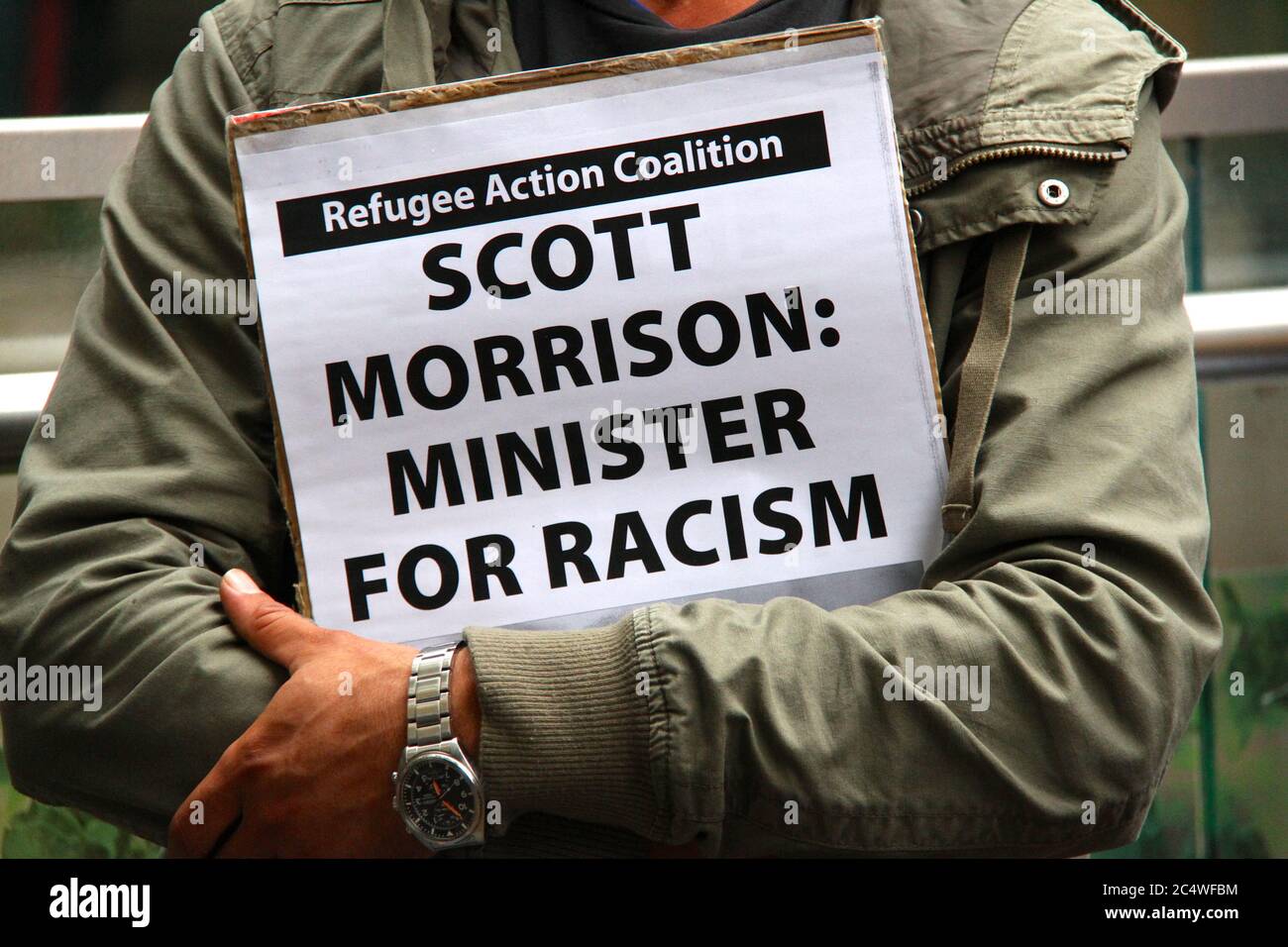 A protester holds a sign saying, ‘Scott Morrison: Minister for Rascism’ at the rally outside Sydney Town Hall. Stock Photo