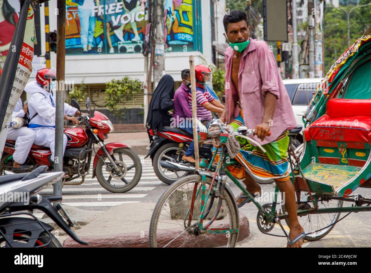 A ricksha-wala, or a rickshaw driver looking for passengers on the streets of Dhaka. Residents in the Bangladesh Capital Dhaka are adjusting to the threat from the COVID 19 corona virus. Stock Photo