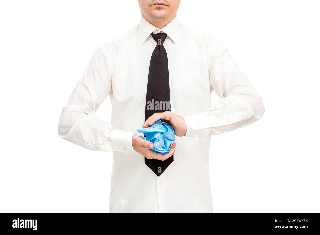 faceless man in white shirt and black tie crumpled bunch of ineffective and useless medical masks in his hands in protest against the quarantine crisi Stock Photo