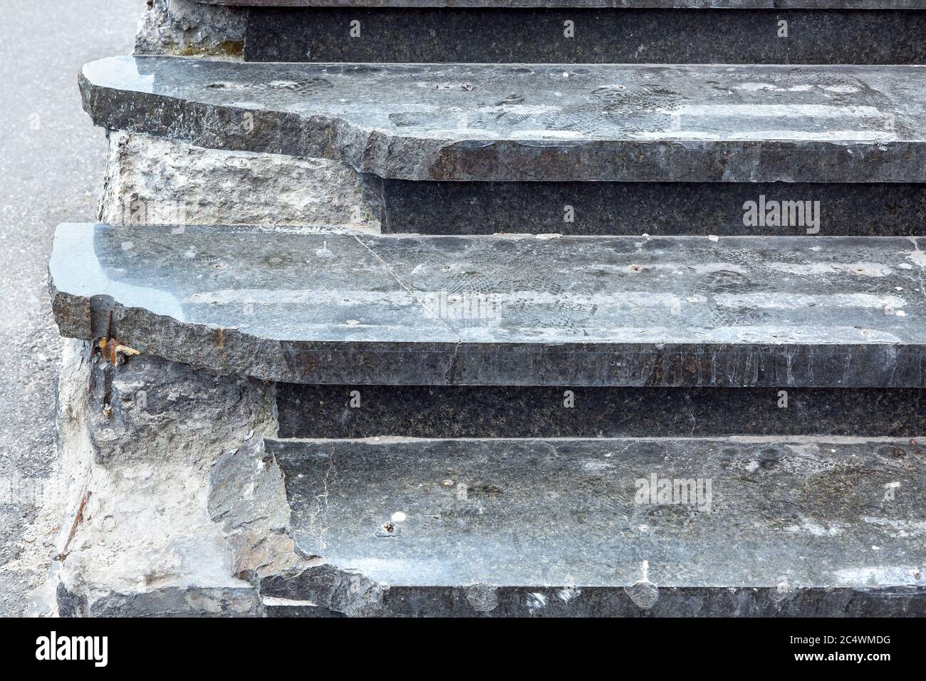 Dark marble steps with broken corners dangerous to climb up, closeup