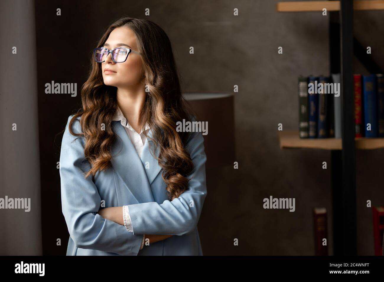 Portrait of amazing young business woman in blue glasses in the office. Stock Photo