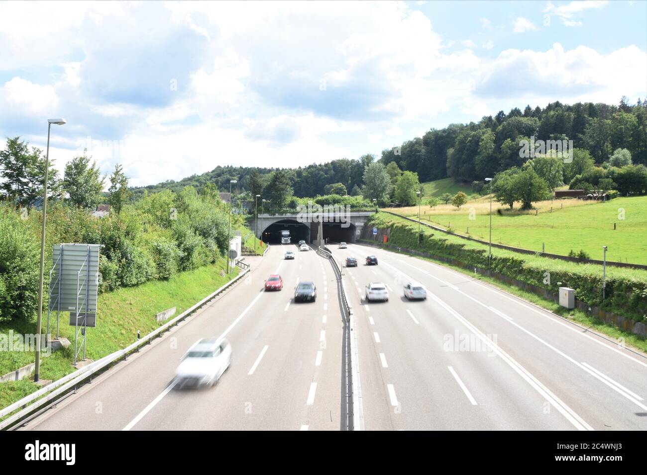 Motor highway with running cars and tunnel Honeret in Switzerland between Dietikon and village Urdorf. Stock Photo