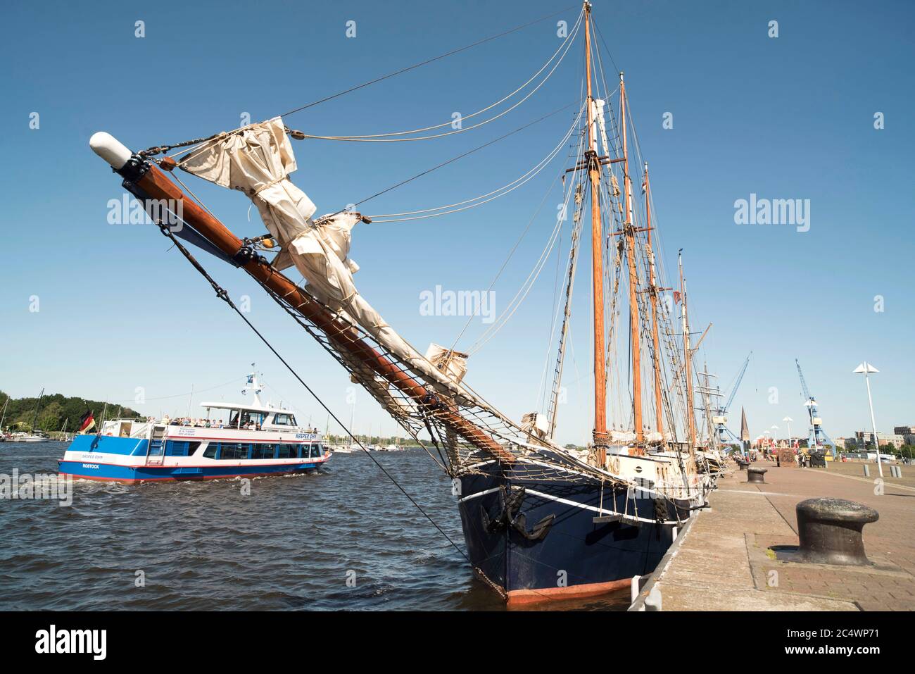 Rostock, Germany. 14th June, 2020. A passenger ship is sailing on the Warnow from the city harbour of the Hanseatic city of Rostock, in the foreground a tall ship at the quay. Credit: Nordlicht Rostock/dpa-Zentralbild/ZB/dpa/Alamy Live News Stock Photo