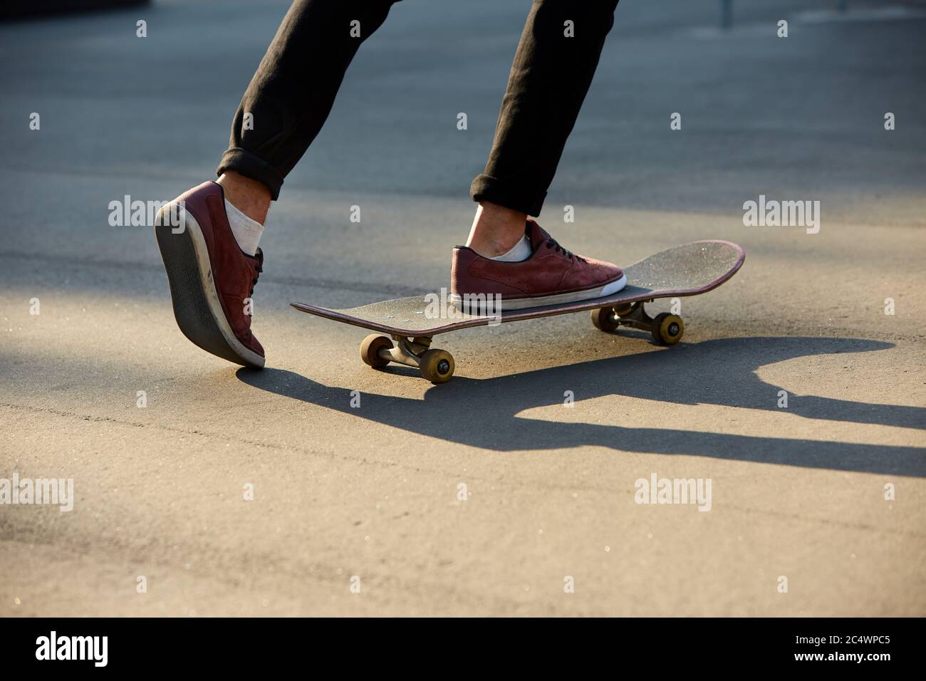 Closeup of skateboarders feet while skating in skate park. Man riding