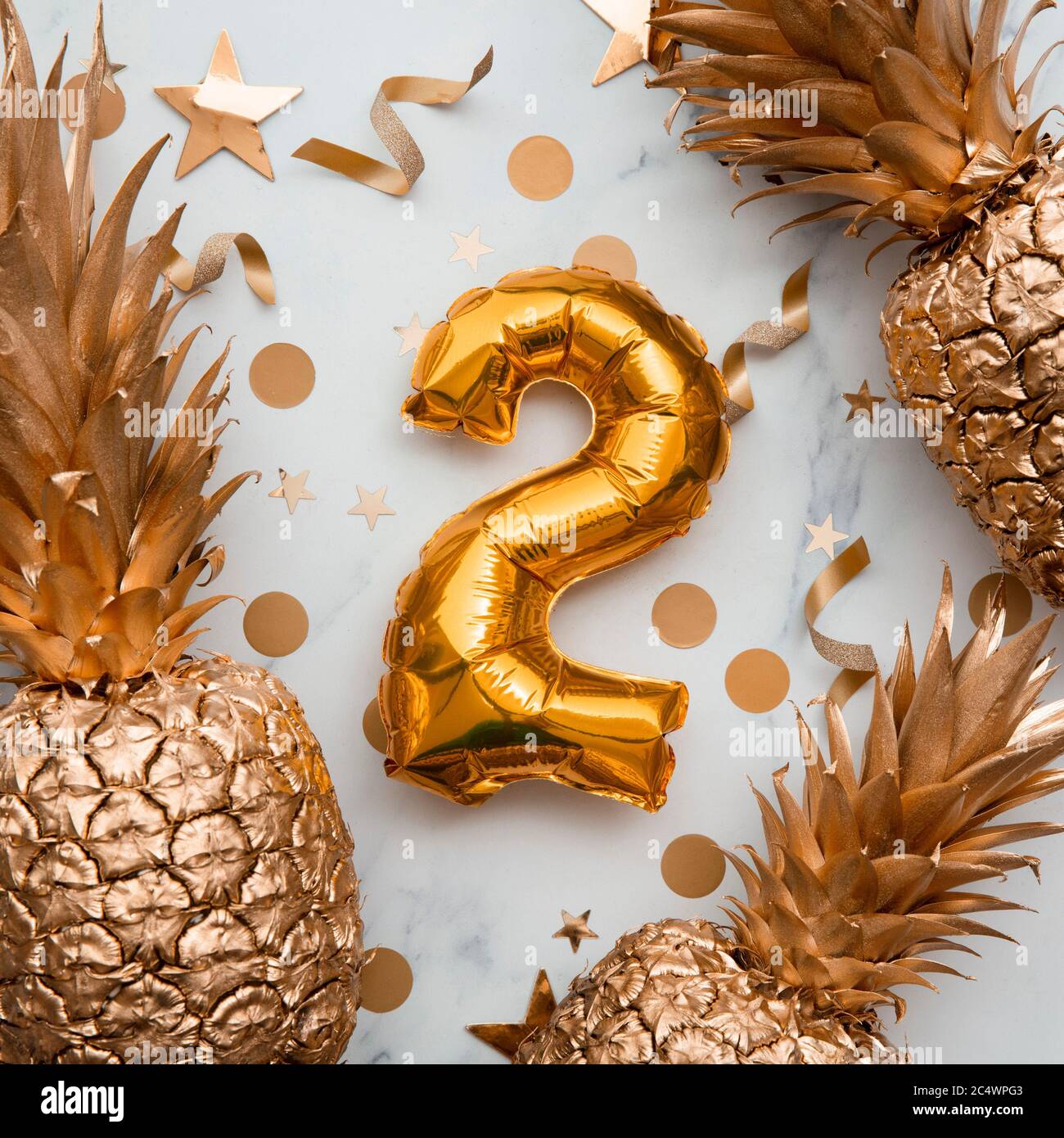 2nd birthday celebration card with gold foil balloons and golden pineapples Stock Photo