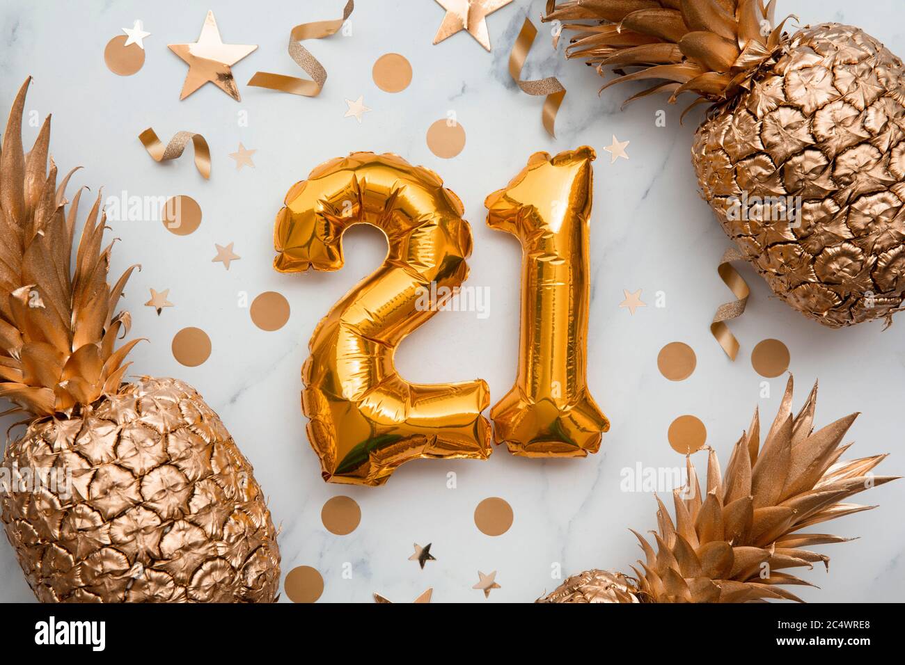21st birthday celebration card with gold foil balloons and golden pineapples Stock Photo