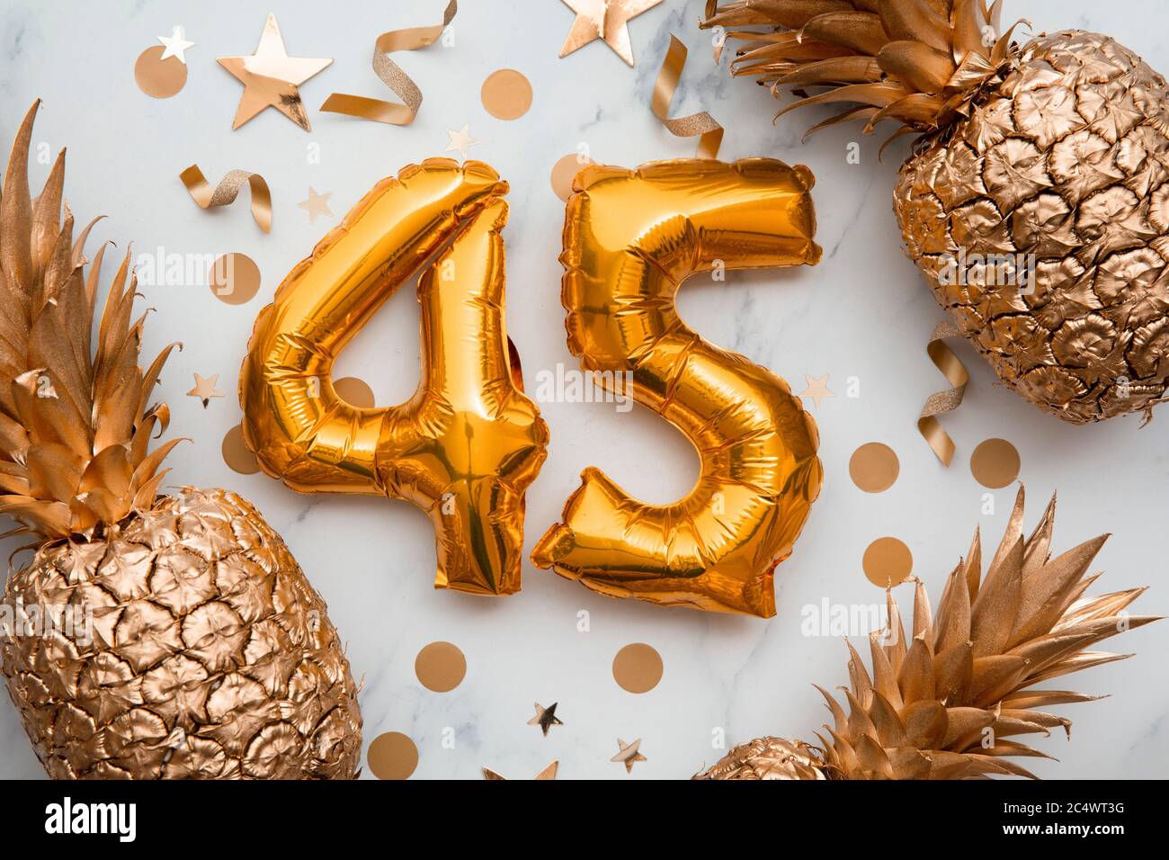 45th birthday celebration card with gold foil balloons and golden pineapples Stock Photo