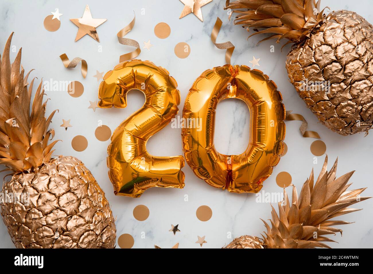 20th birthday celebration card with gold foil balloons and golden pineapples Stock Photo