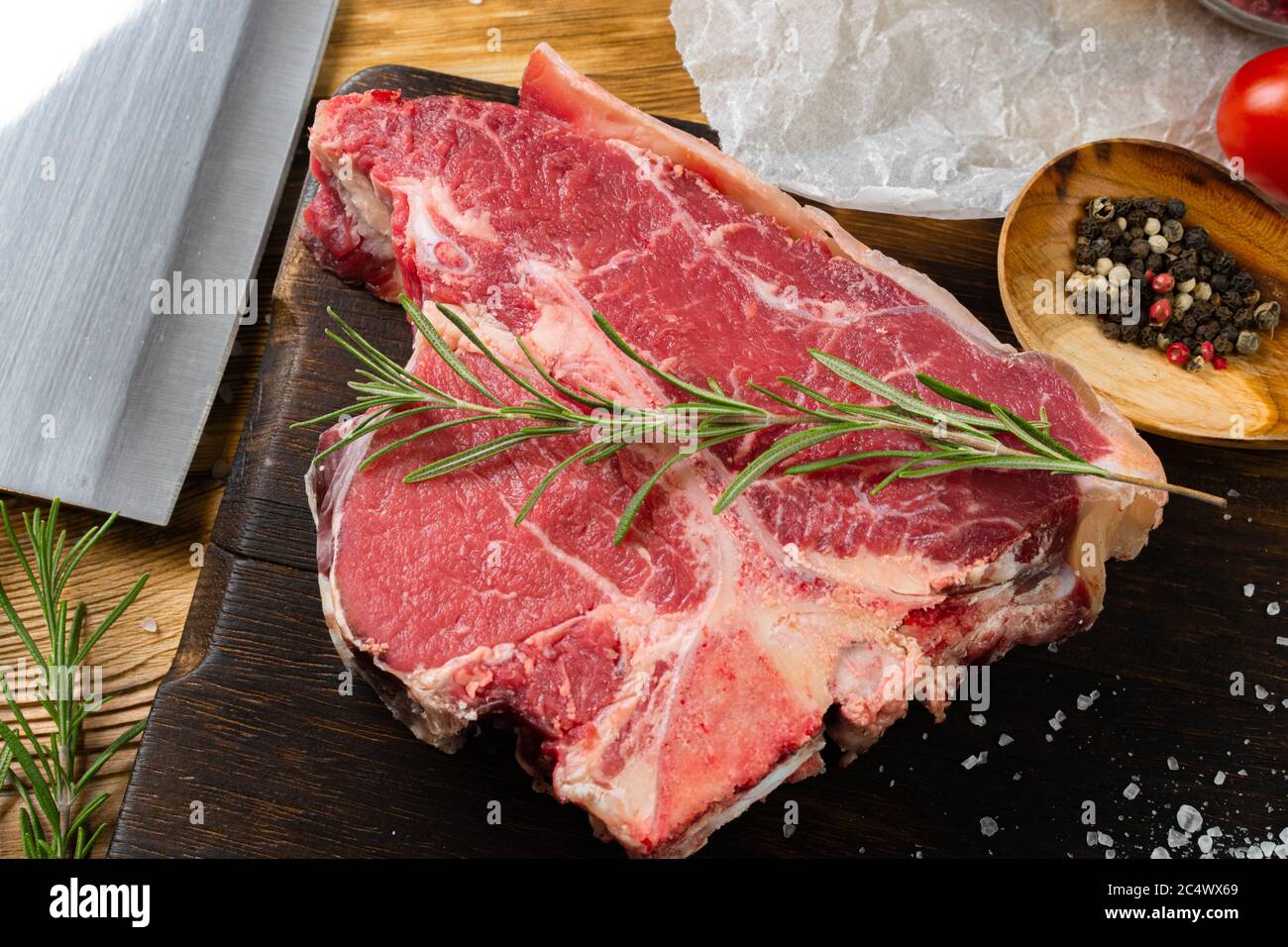 Raw T-bone steak with herbs on wooden board Stock Photo - Alamy