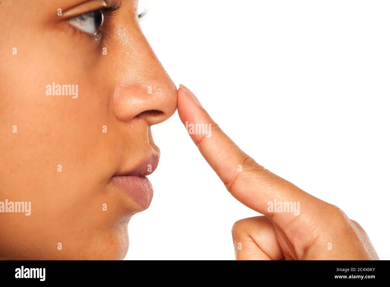 Young dark skinned woman touching her nose Stock Photo