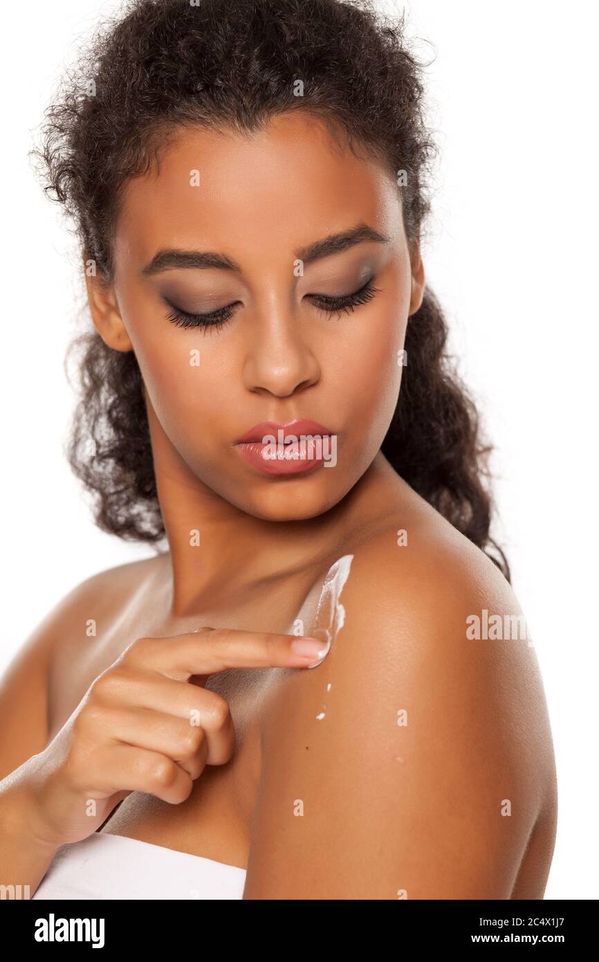 Beautiful Dark Skinned Woman Applying Body Lotion On White Background Stock Photo Alamy