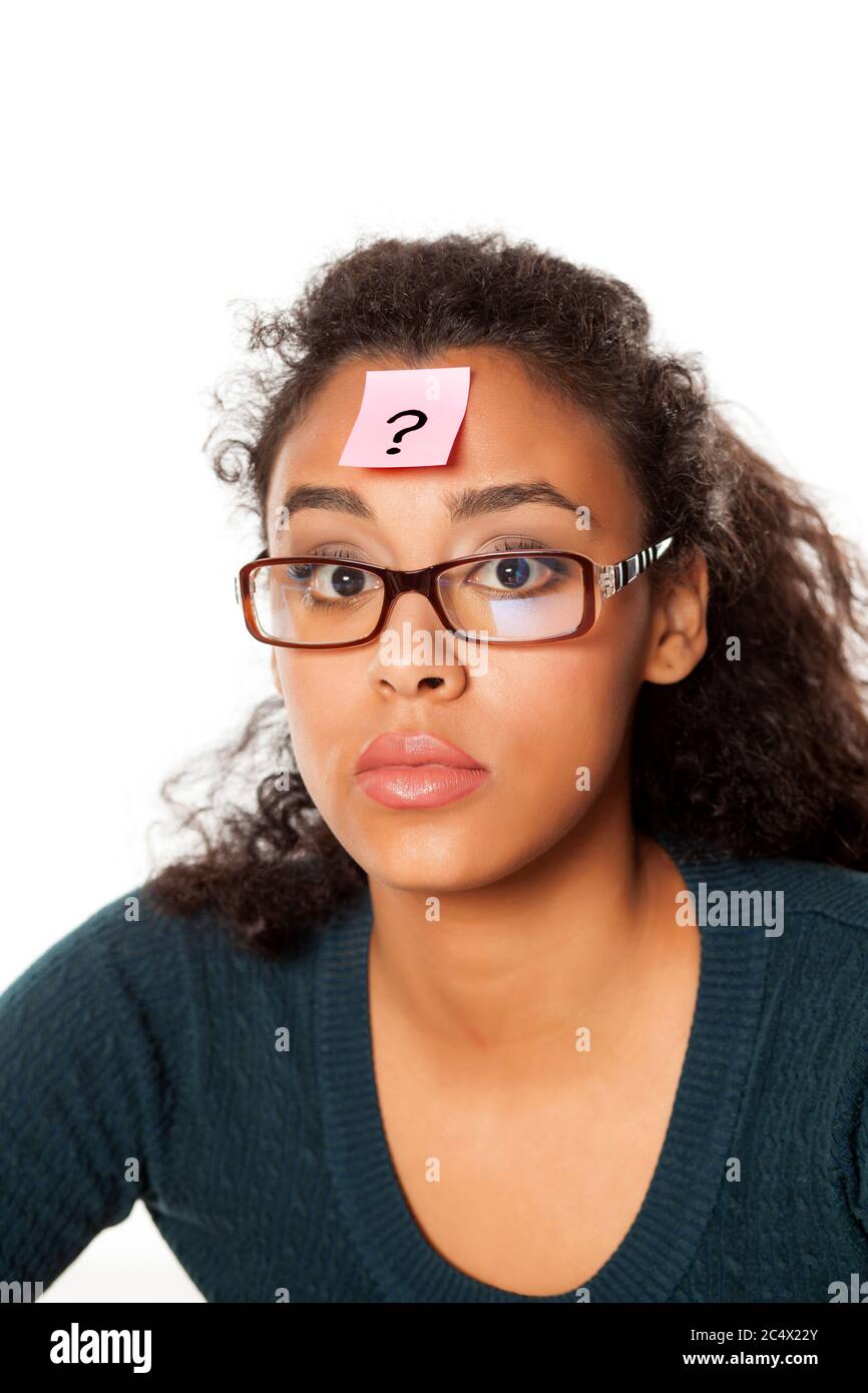 portrait of confused young dark-skinned woman with question mark on her forehead on a white background Stock Photo