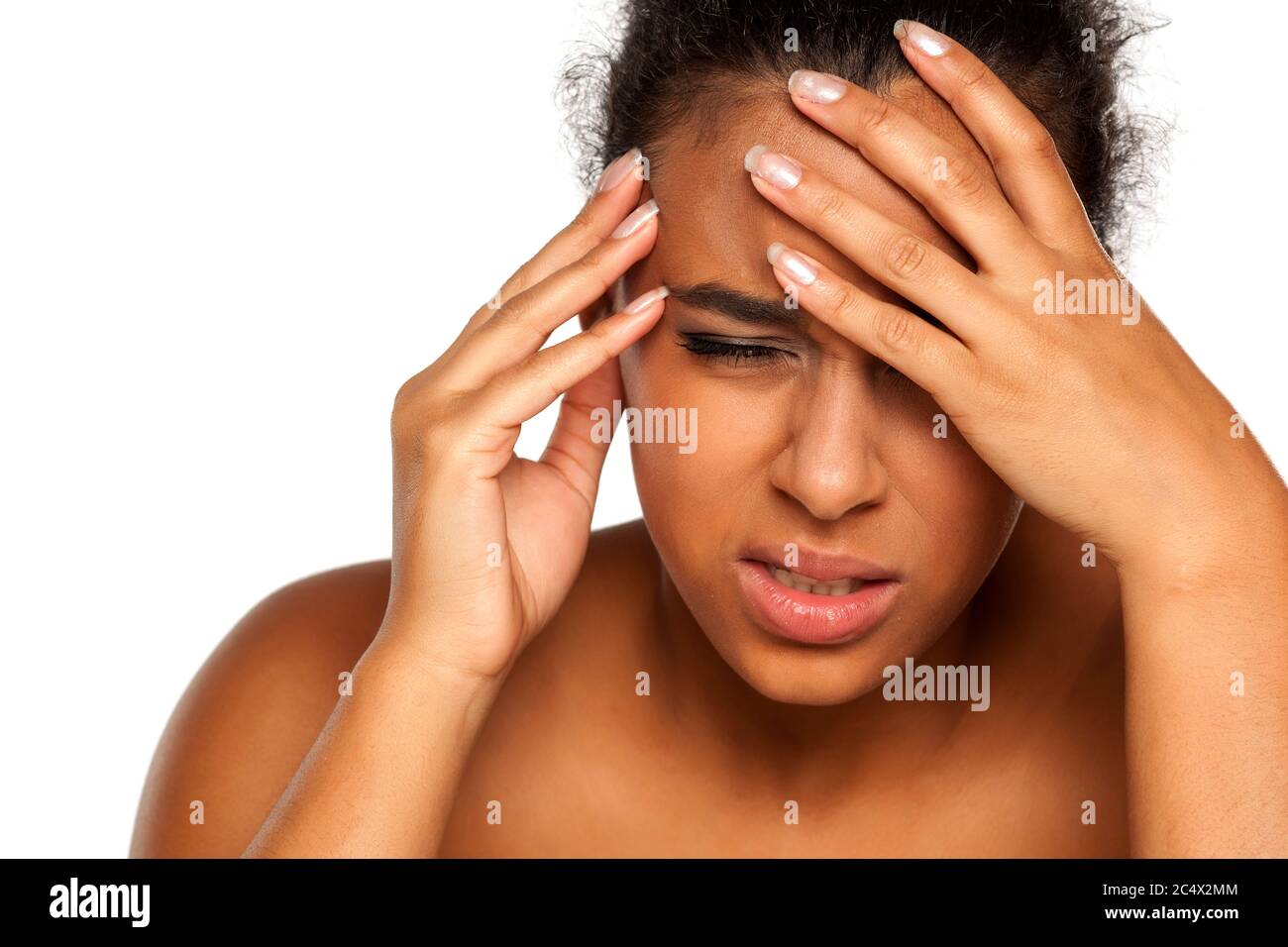 portrait of young dark-skinned woman with headache on white background Stock Photo