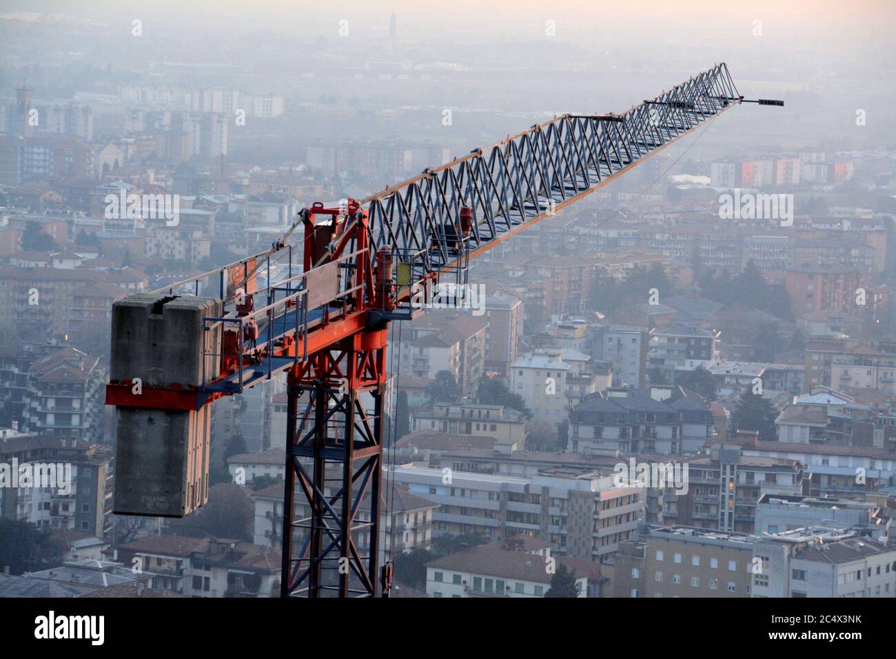 Large and tall construction crane overlooking a city Stock Photo
