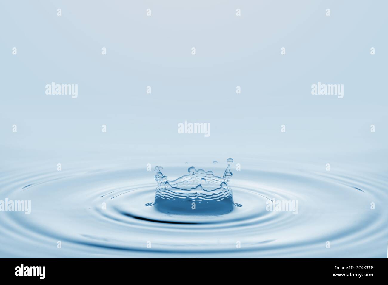 Water splash isolated on blue background. Stock Photo