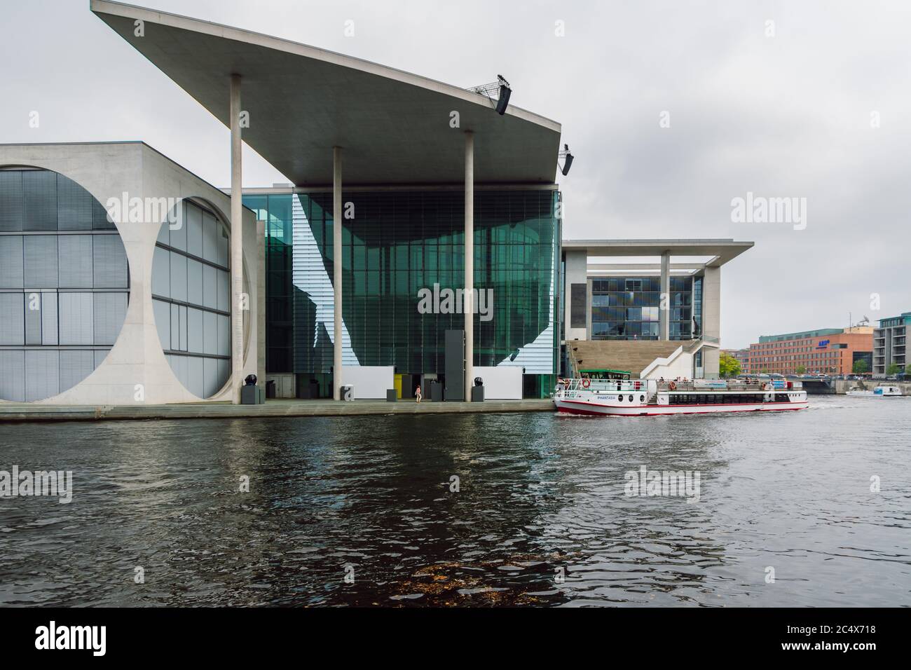 View of the Marie Elisabeth Luders Haus modern parliamentary building and the Spree river with tourist sightseeing boat in Berlin. Stock Photo