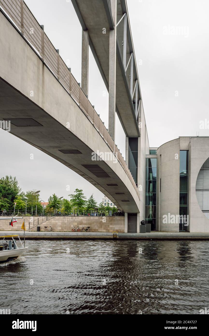 Vertical shot of a modern concrete bridge over the Spree River. Modernist architecture of the Chancellery building, Berlin, Germany. Stock Photo