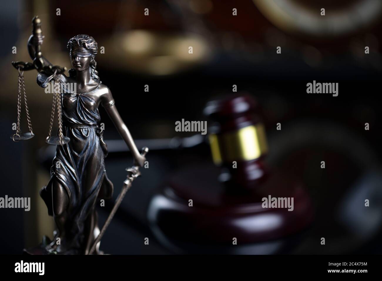Law concept. Judge wooden gavel, scale, old clock and Themis statue on brown background in