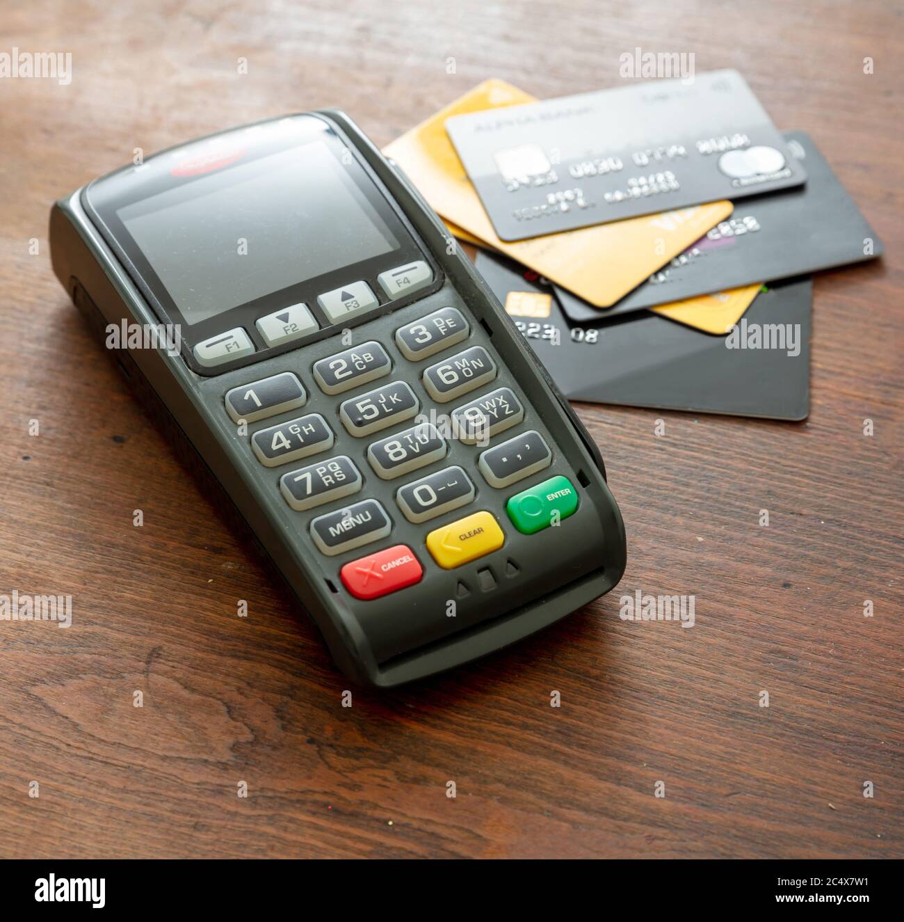 POS terminal and credit cards on wooden background, Terminal cash register machine for contactless payment. Banking equipment, Consumerism, shopping c Stock Photo