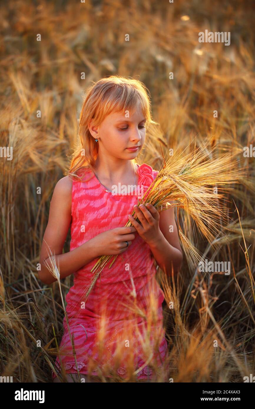 Beautiful little girl in red in a wheat field Stock Photo - Alamy