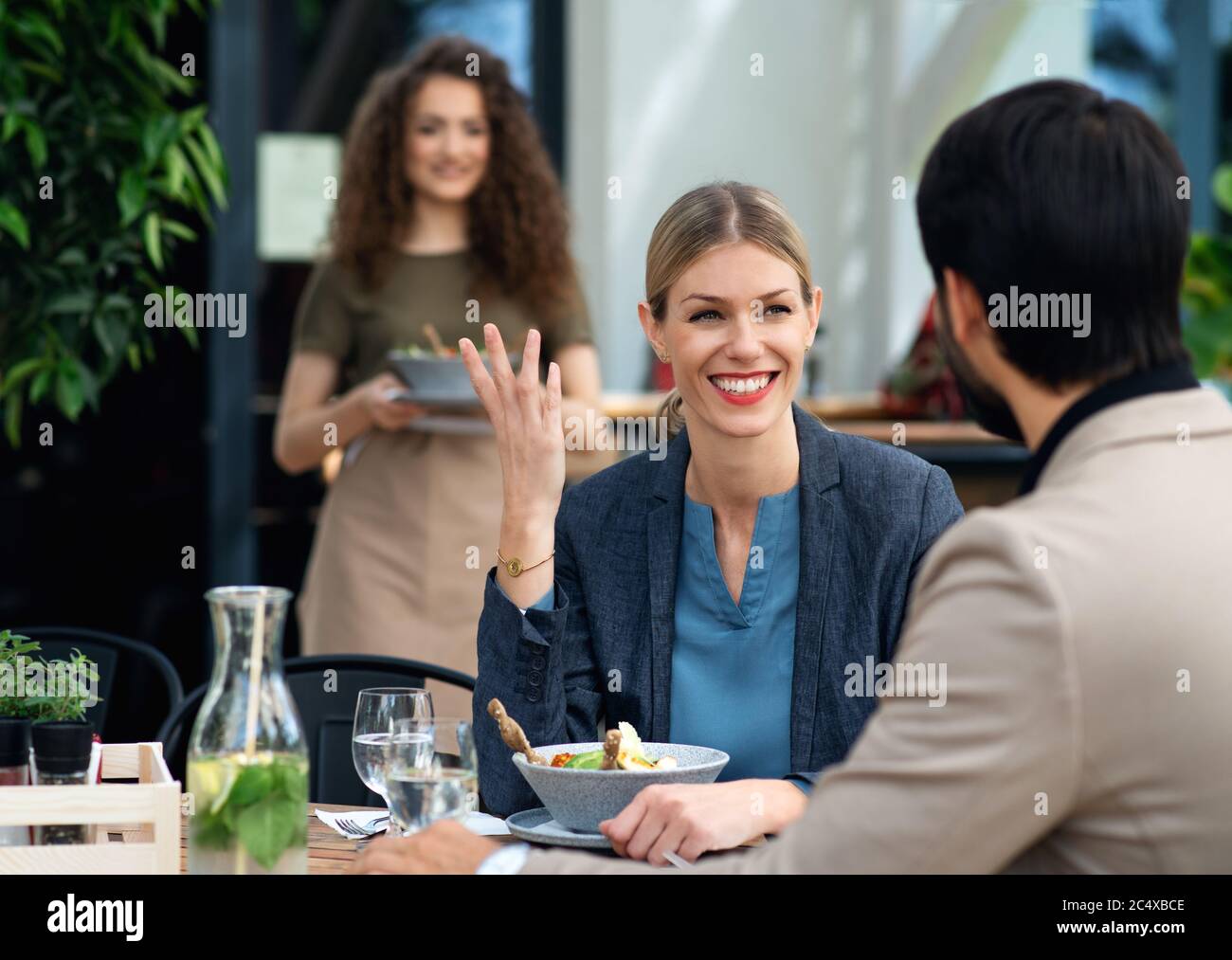 Happy couple sitting outdoors on terrace restaurant, eating Stock Photo ...
