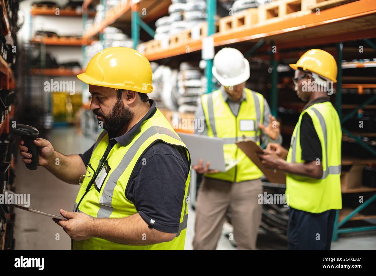 Three male factory workers checking stock at the factory Stock Photo