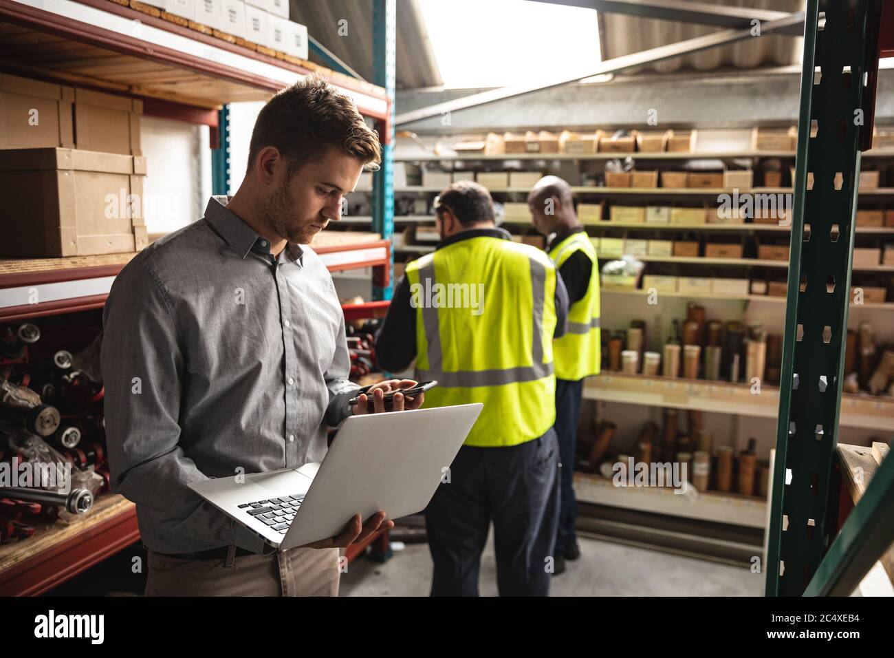 Male factory worker with laptop using smartphone at the factory Stock ...