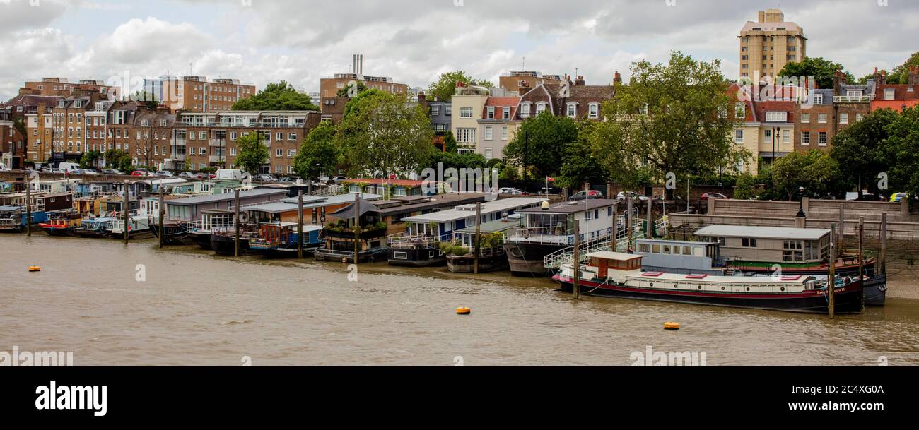 Houseboats moored by Cheyne Row, Chelsea on bank of river Thames in