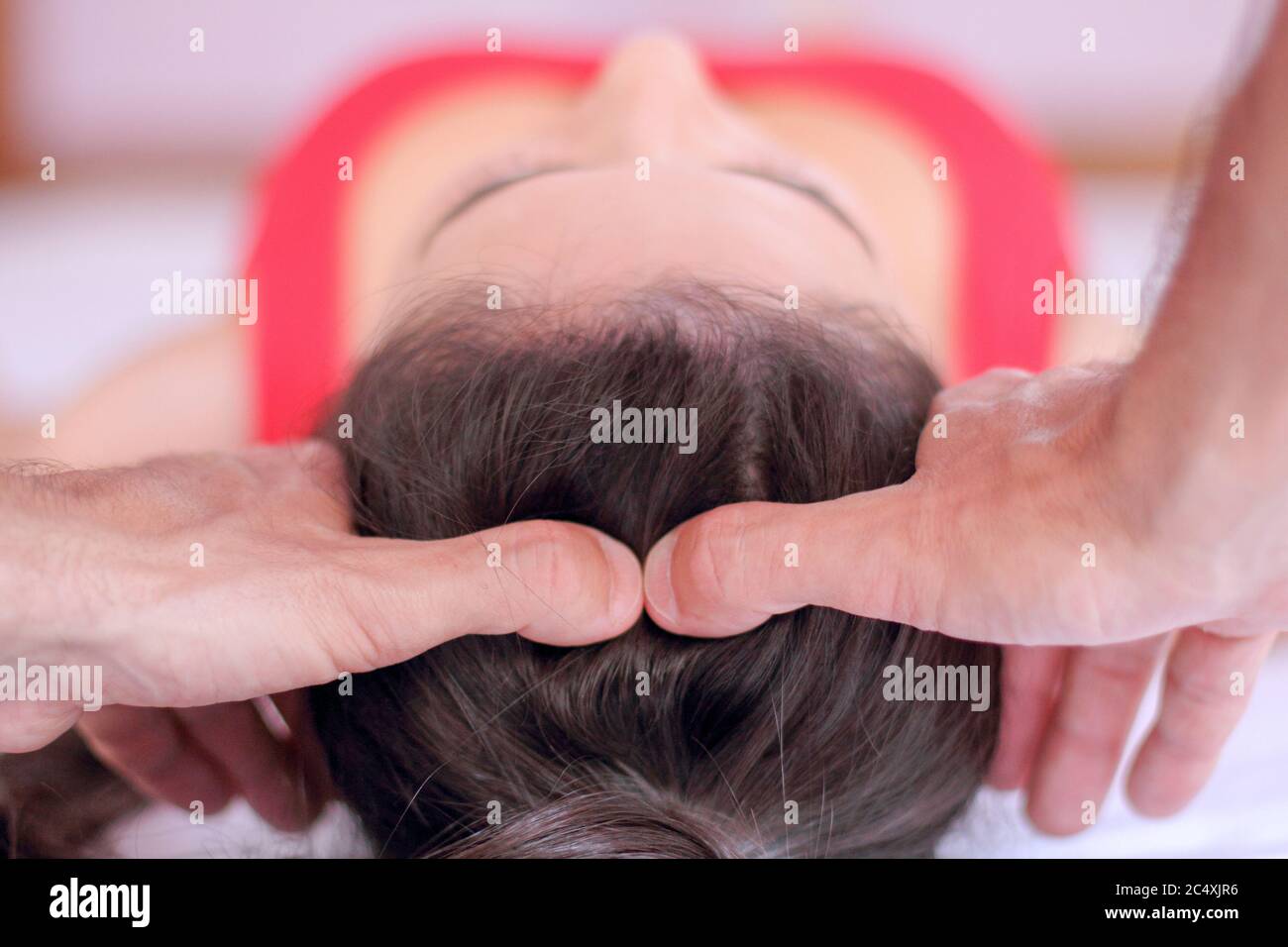 Horizontal view of Shiatsu Head massage therapy on female patient dressed  in red Stock Photo - Alamy