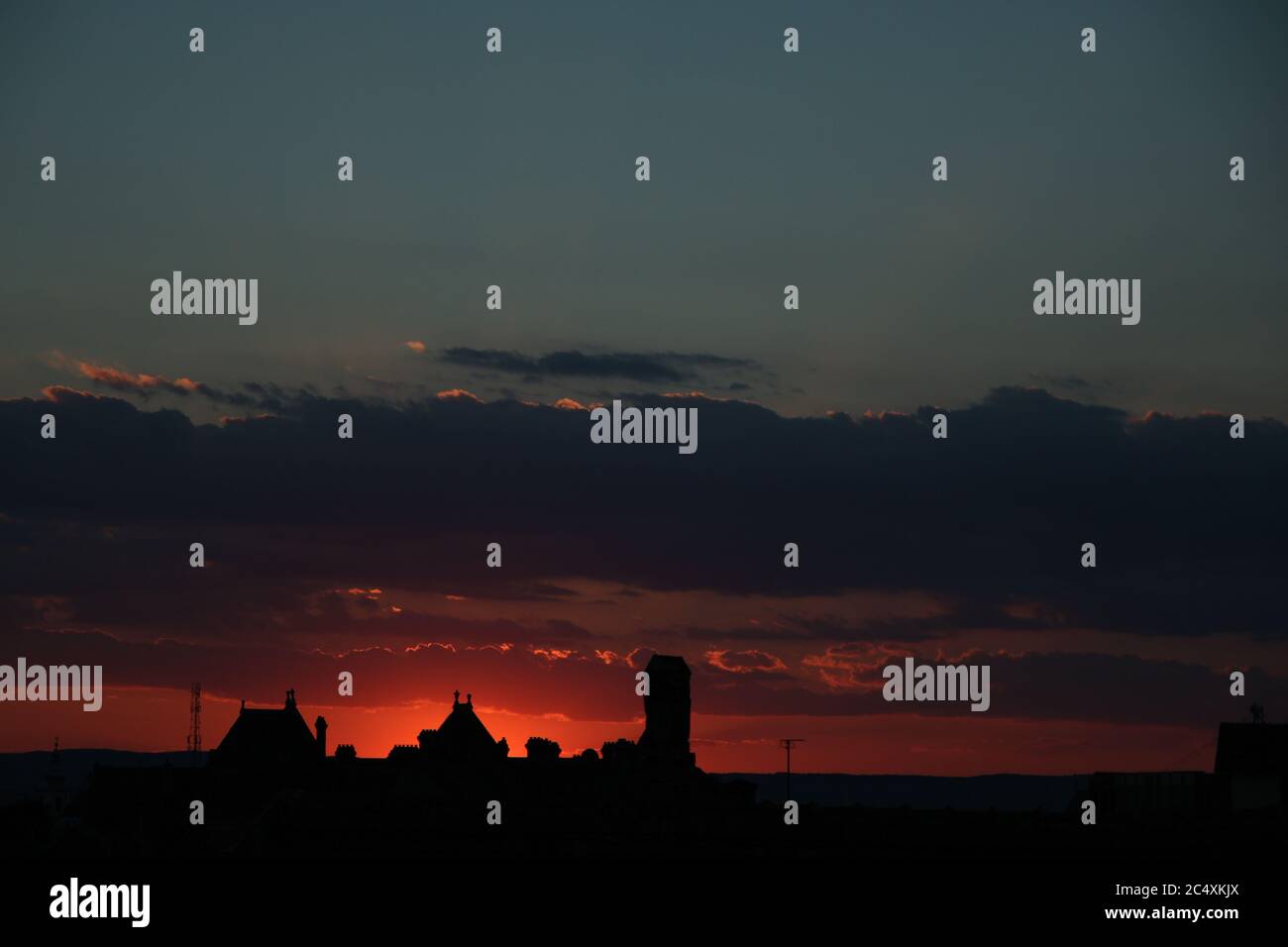 Concept of calm and serenity. Colorful and cloudy sunset in the background. Sibiu, Romania, old medieval town in eastern central Europe. Fiery red sun Stock Photo