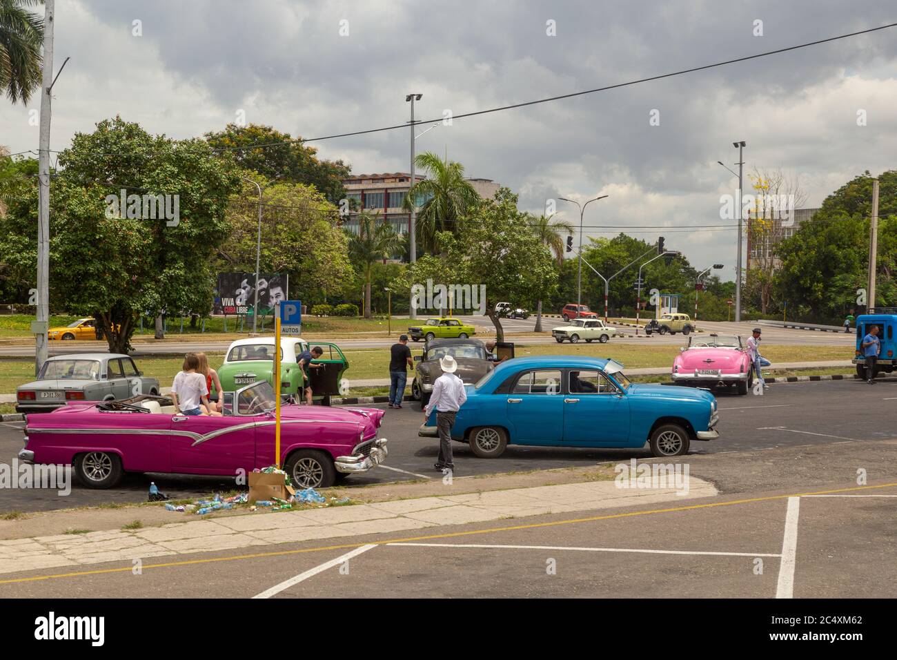 HAVANA, CUBA - CIRCA 2017: group of American green classic taxi cars waiting for tourists in Plaza de la Revolucion in Vedado Cuba Stock Photo