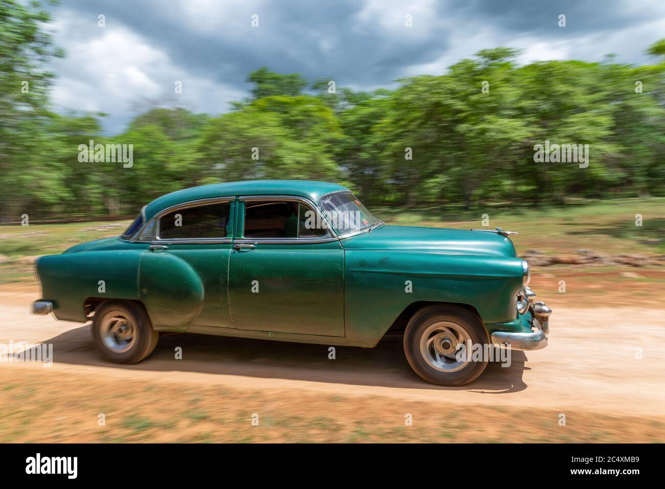 HAVANA, CUBA - CIRCA 2017: Panning on an American green classic car in the streets of Havana, transporting tourists. Concept of tourism having fun. Stock Photo