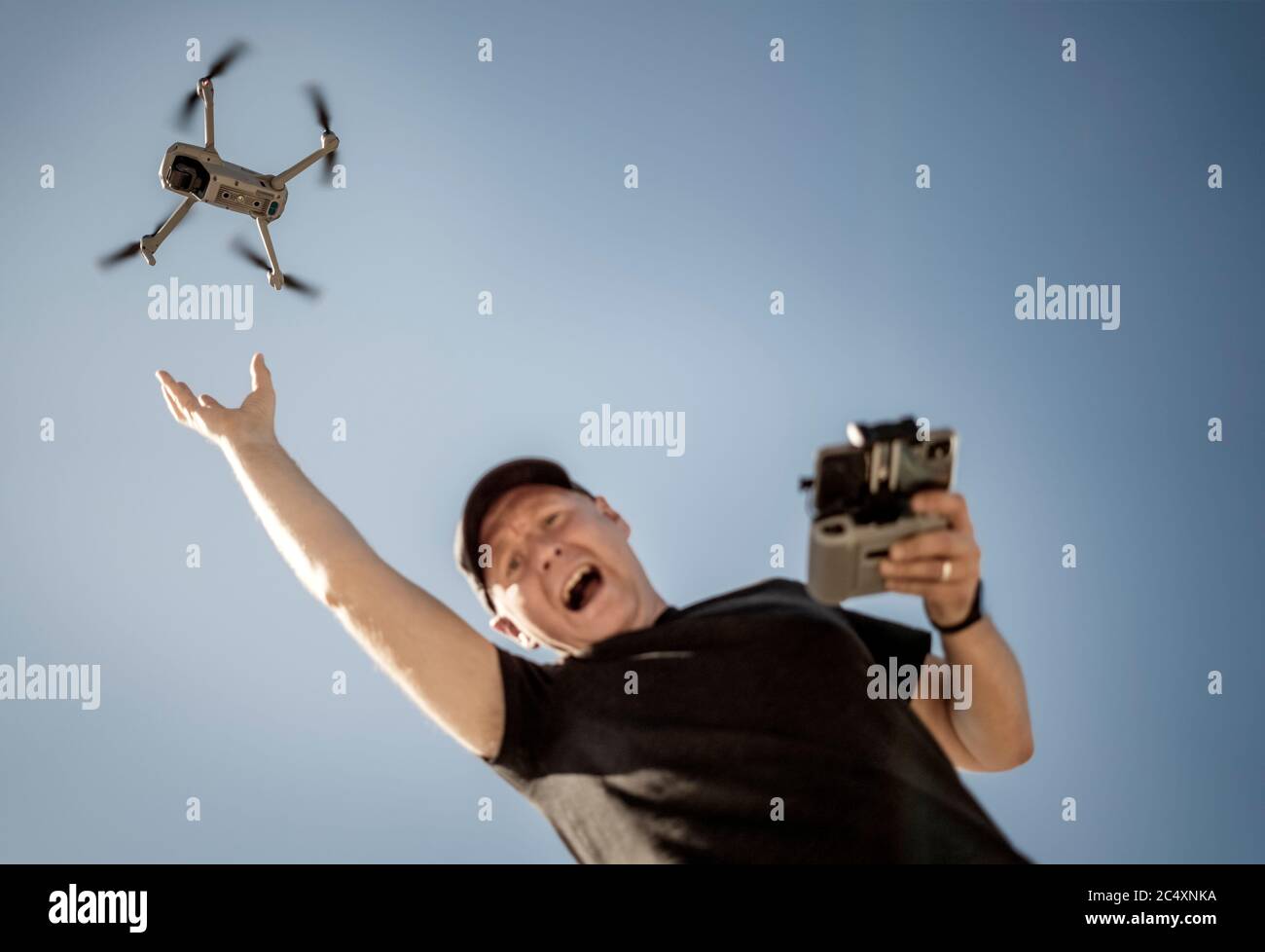 Desperate man tries to catch drone that flies away Stock Photo