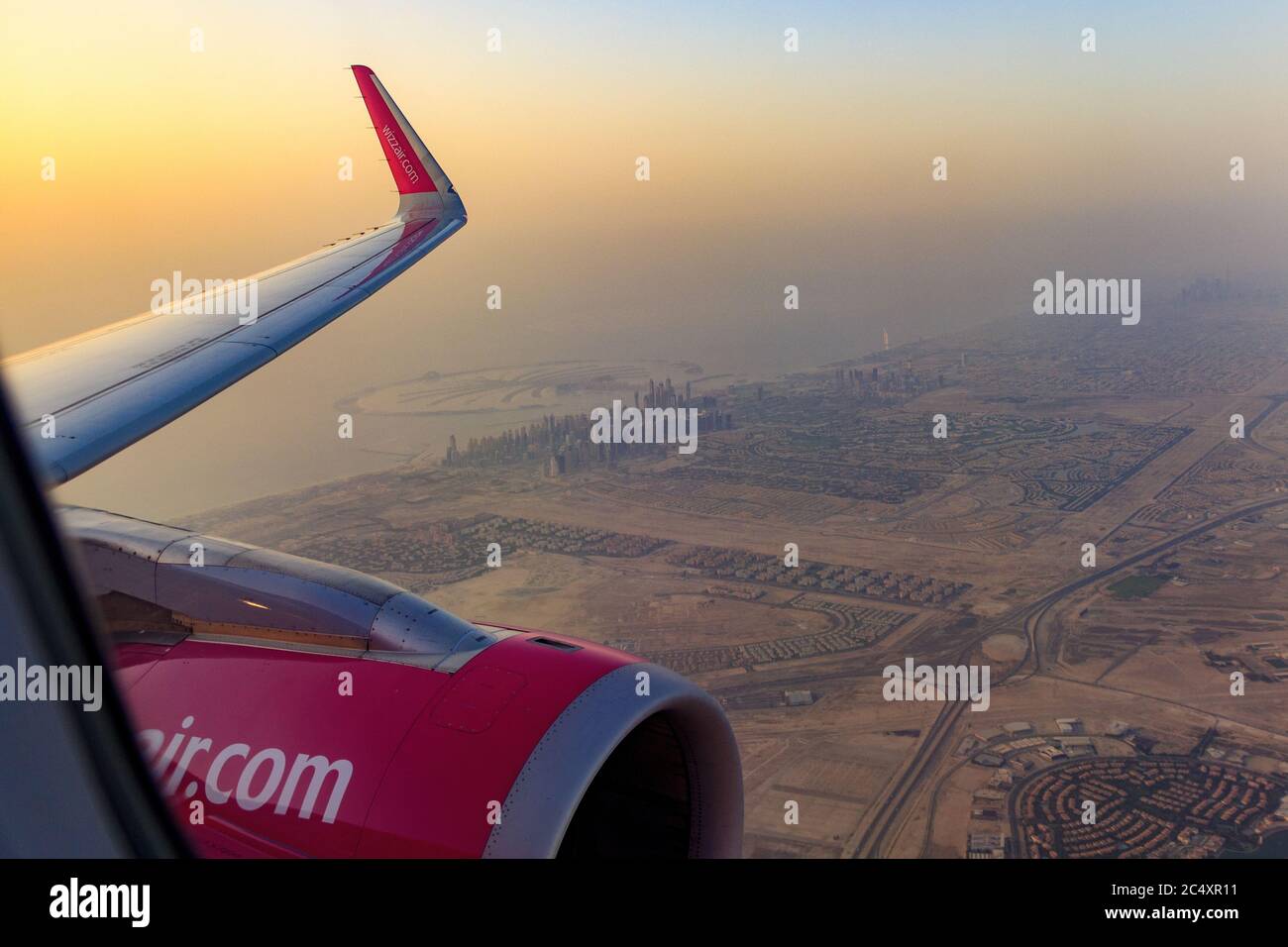 DUBAI, UAE - CIRCA 2020: View of Dubai skyline from an airplane during a colorful sunset. View of Persian Golf and Dubai skyscrapers. Stock Photo