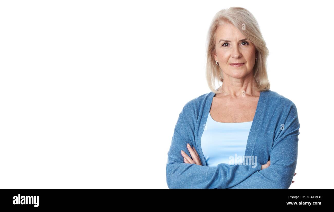 portrait of happy middle-aged female is smiling at camera isolated over white studio wall Stock Photo