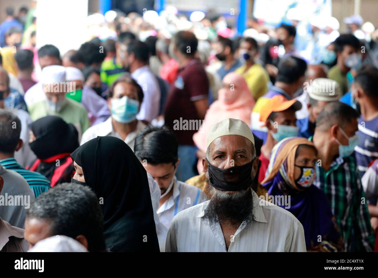 Dhaka, Bangladesh - June 29, 2020: Without maintaining social distancing, people stand in queues to pay their water bills at the Jatrabari wasa office Stock Photo