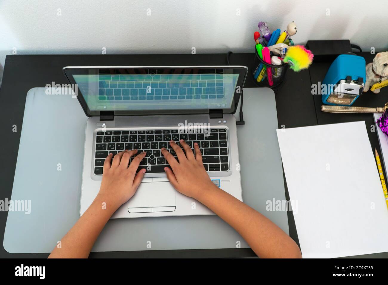 A view from the top of a young student makes use of a laptop for her e-learning class. Stock Photo