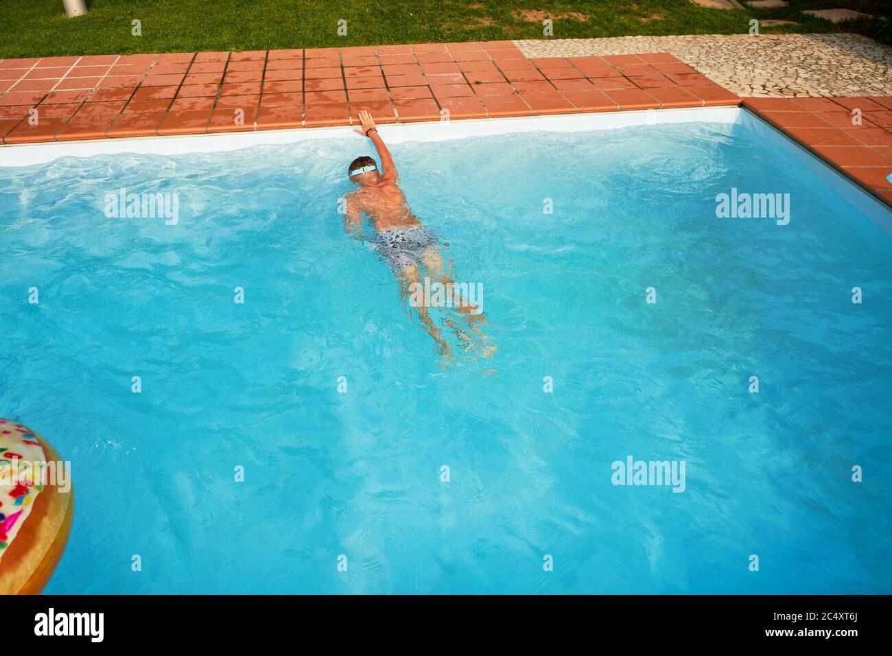 Boy swimming in the open pool in summer Stock Photo