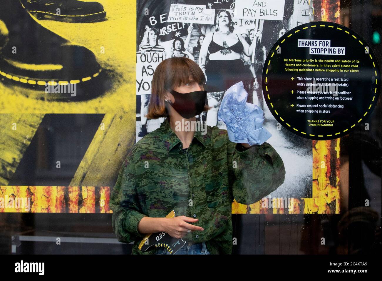 A member of staff at the Dr Martens shop in Edinburgh's Princes Street  makes preparations as non-essential stores across the country reopen today  as part of Scotland's phased plan to ease out