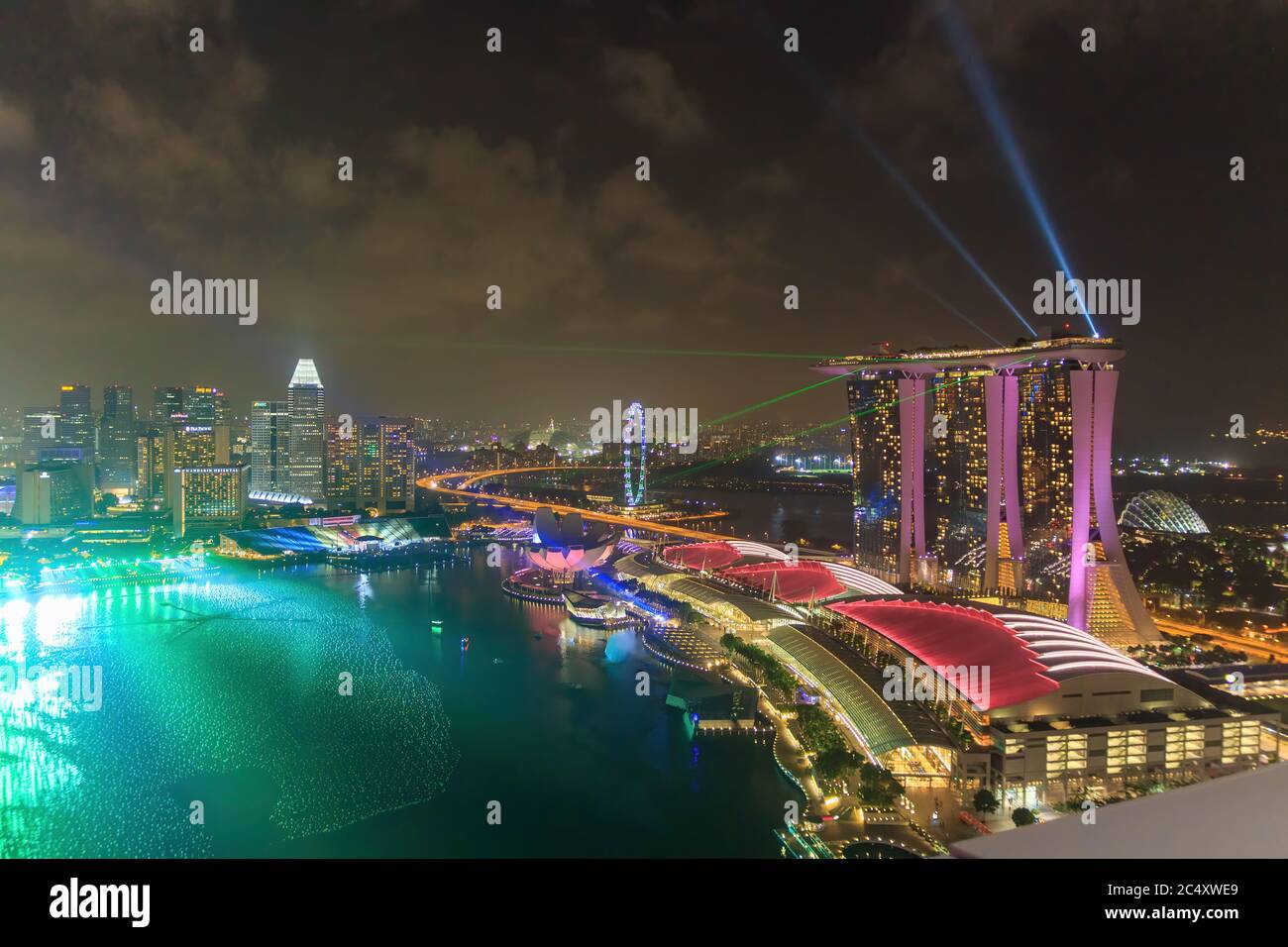 Singapore - CIRCA 2020: Skyline in Marina Bay, view of Art Museum, famous hotel and Singapore Flyer during the night with a stormy sky on the backgrou Stock Photo