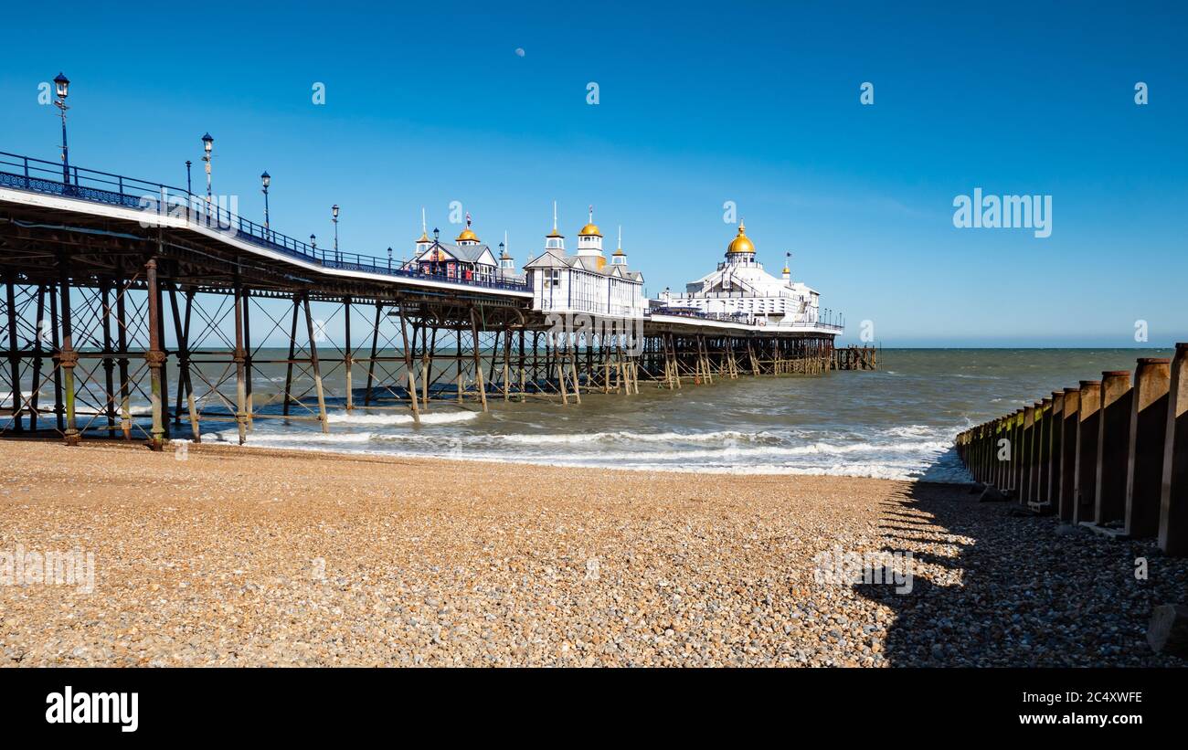 Eastbourne Pier and pebble beach, East Sussex, England. The landmark pier in the popular English seaside resort on a bright and sunny spring day. Stock Photo