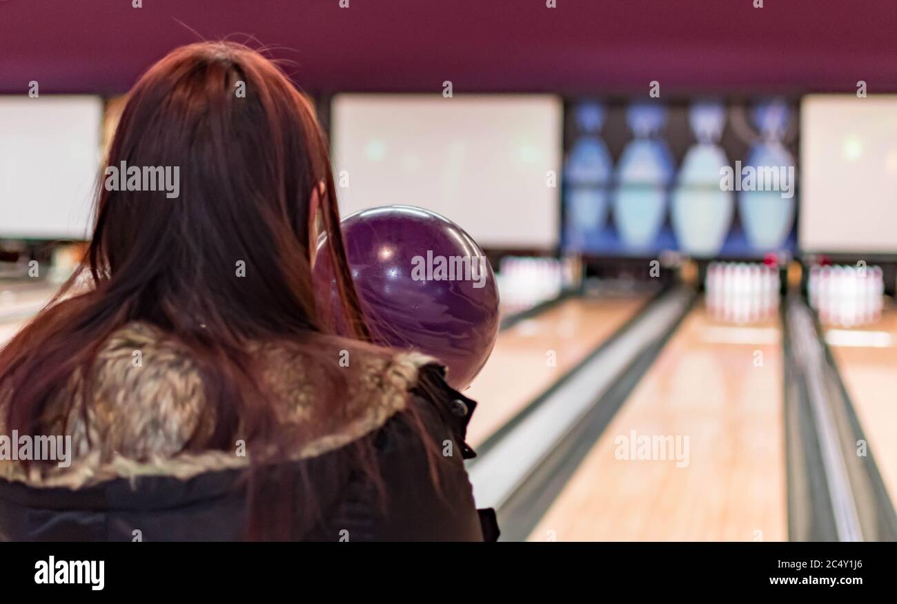 A bowling ball while being aimed to the target by a female adult in a