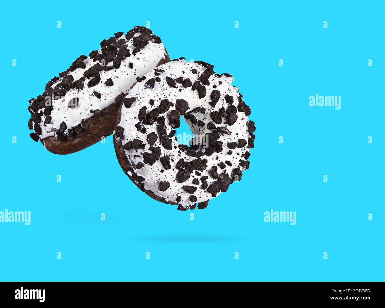 Two chocolate donuts isolated on blue background. Stock Photo
