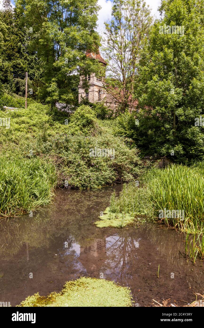 Christ Church reflected in the disused Thames and Severn Canal at Chalford, Gloucestershire UK Stock Photo