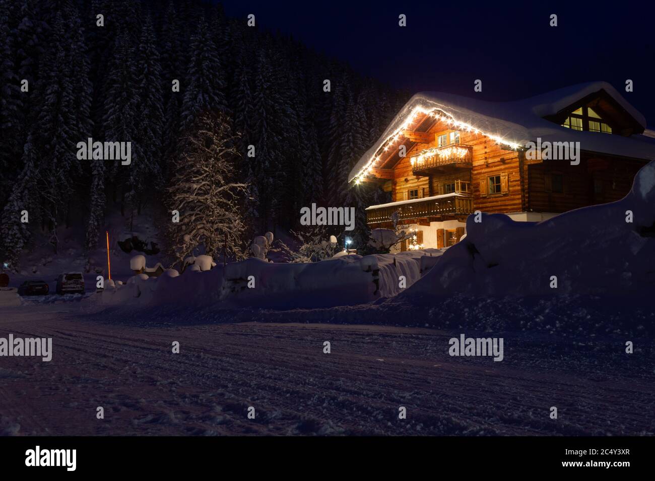 Beautiful Austrian cottage home covered with snow and decorated christmas lights during Winter Stock Photo