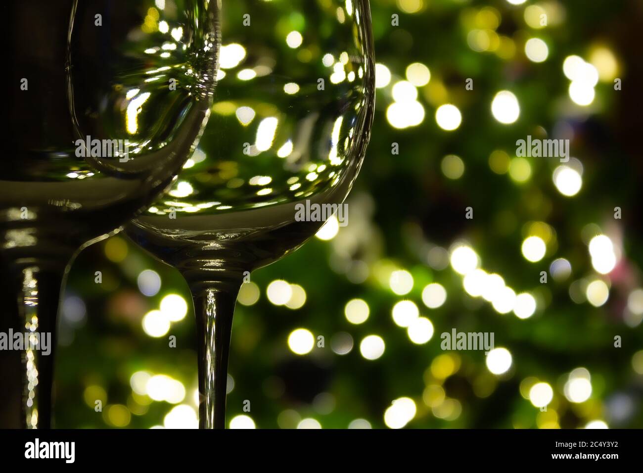 Multiple wine glasses with blurred christmas tree lights in the background Stock Photo